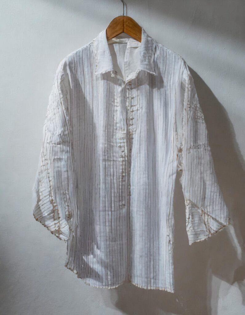 Firefly camisa artesanal o guayabera secandose bajo la sombra con un fondo minimalista blanco detal 796x1024 1